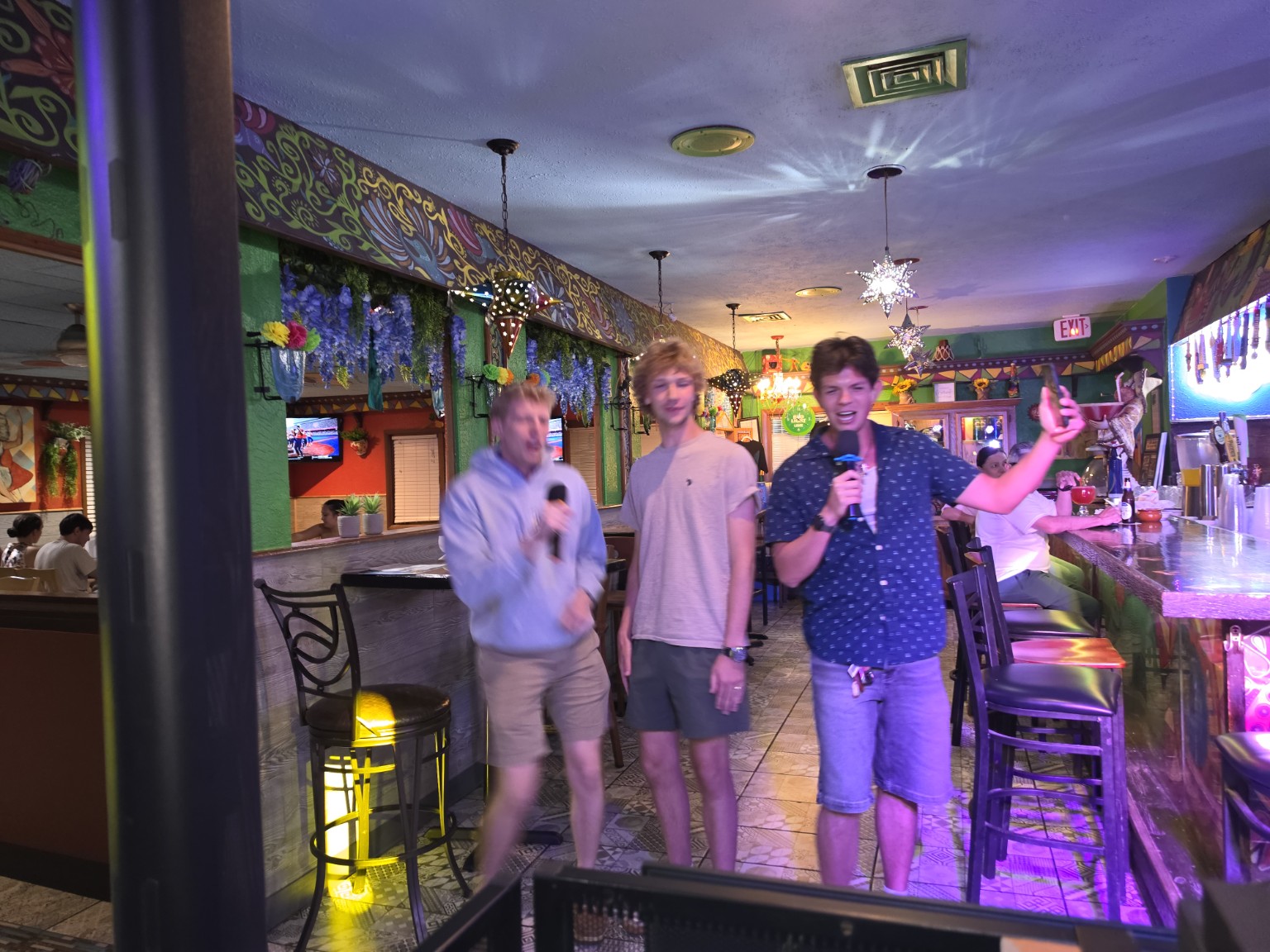 Three friends singing karaoke at Los Cabos