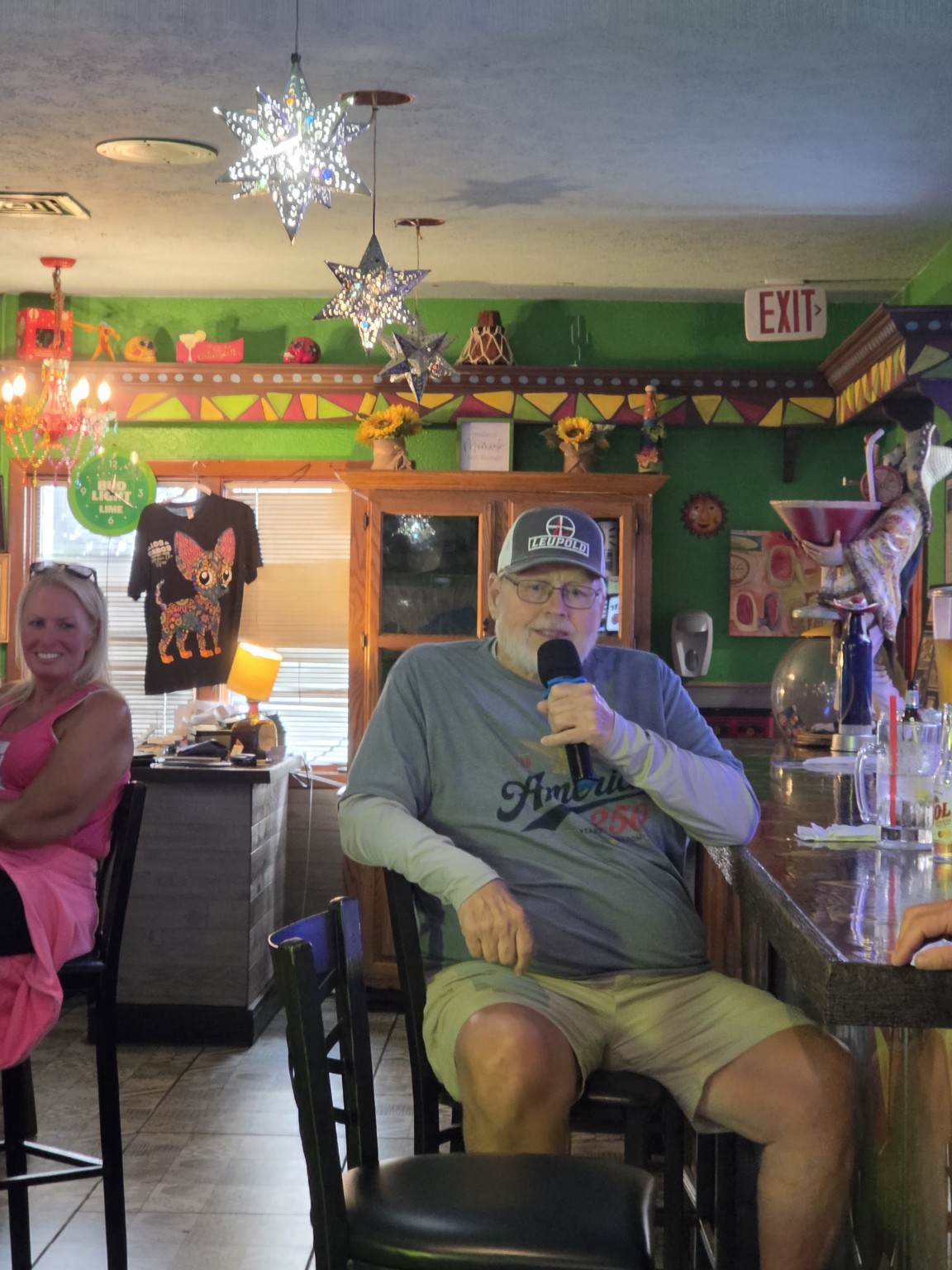 Seated singer performing karaoke at Los Cabos