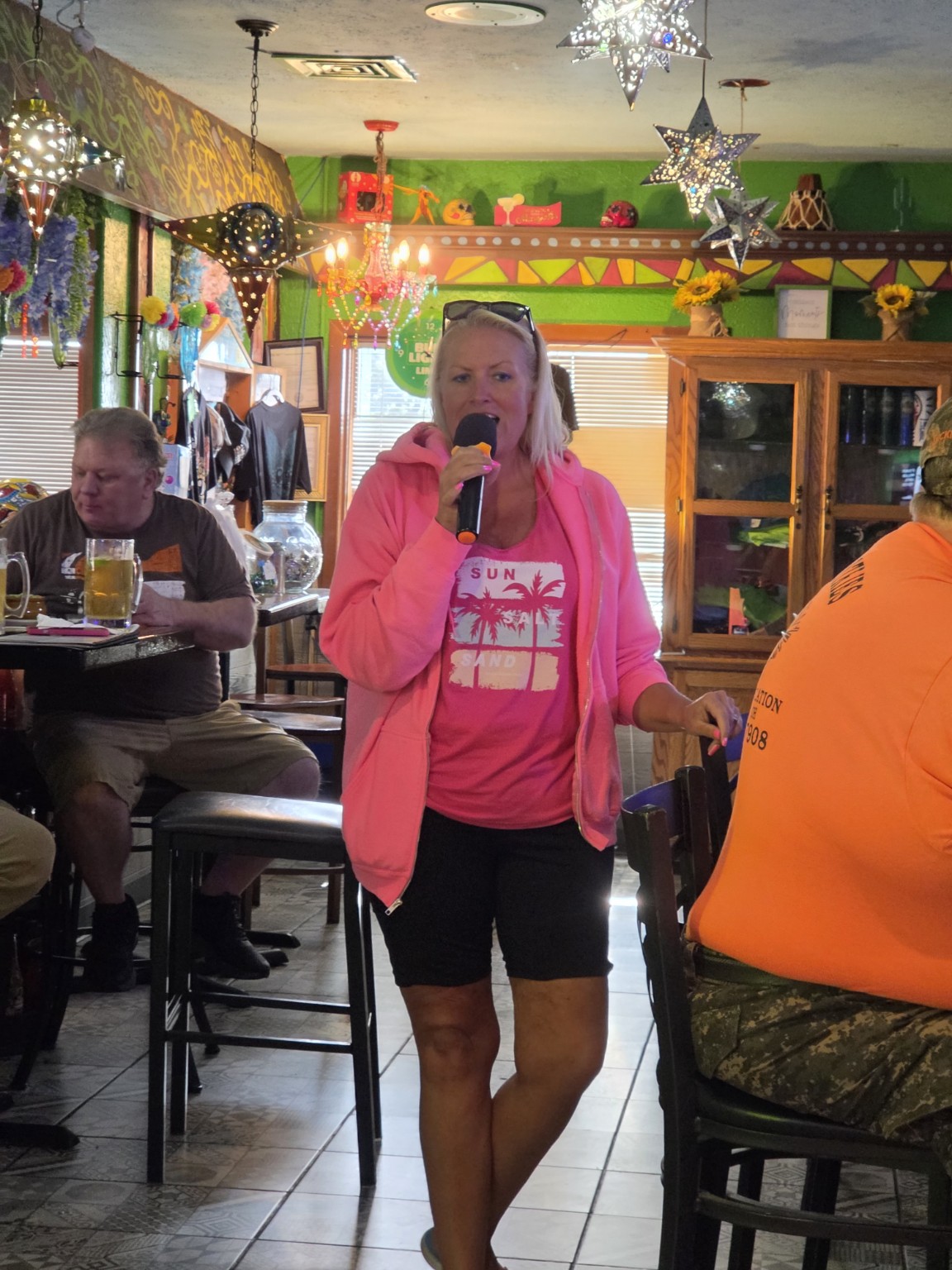 Singer performing in a bright pink outfit at Los Cabos