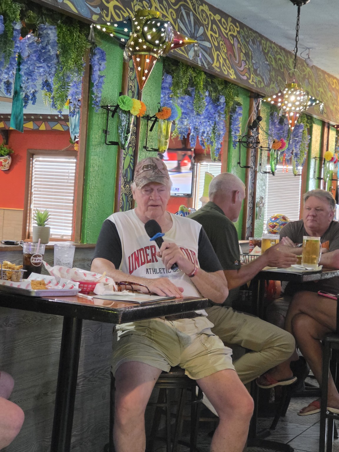 Guest singing karaoke from a table at Los Cabos
