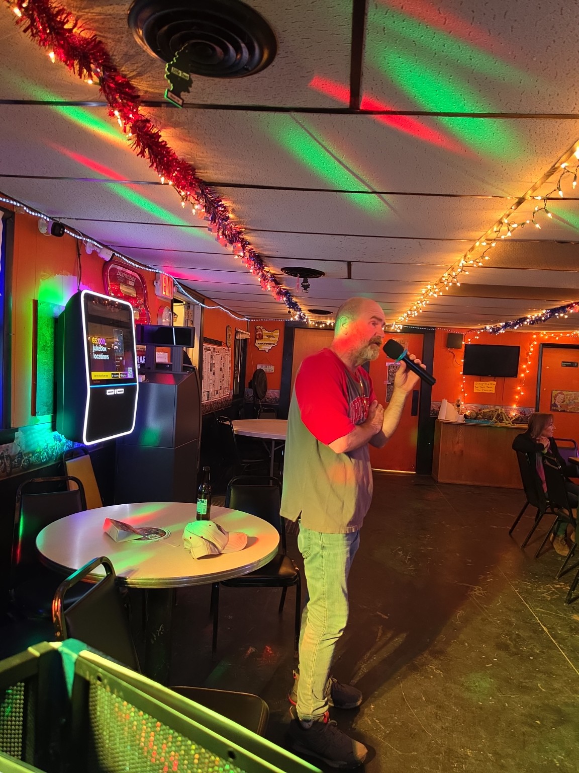 Singer performing karaoke under colorful lights
