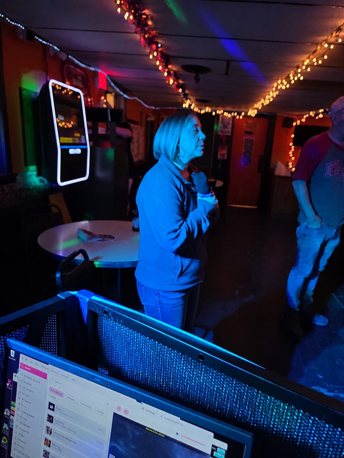 Woman singing karaoke in blue stage lighting