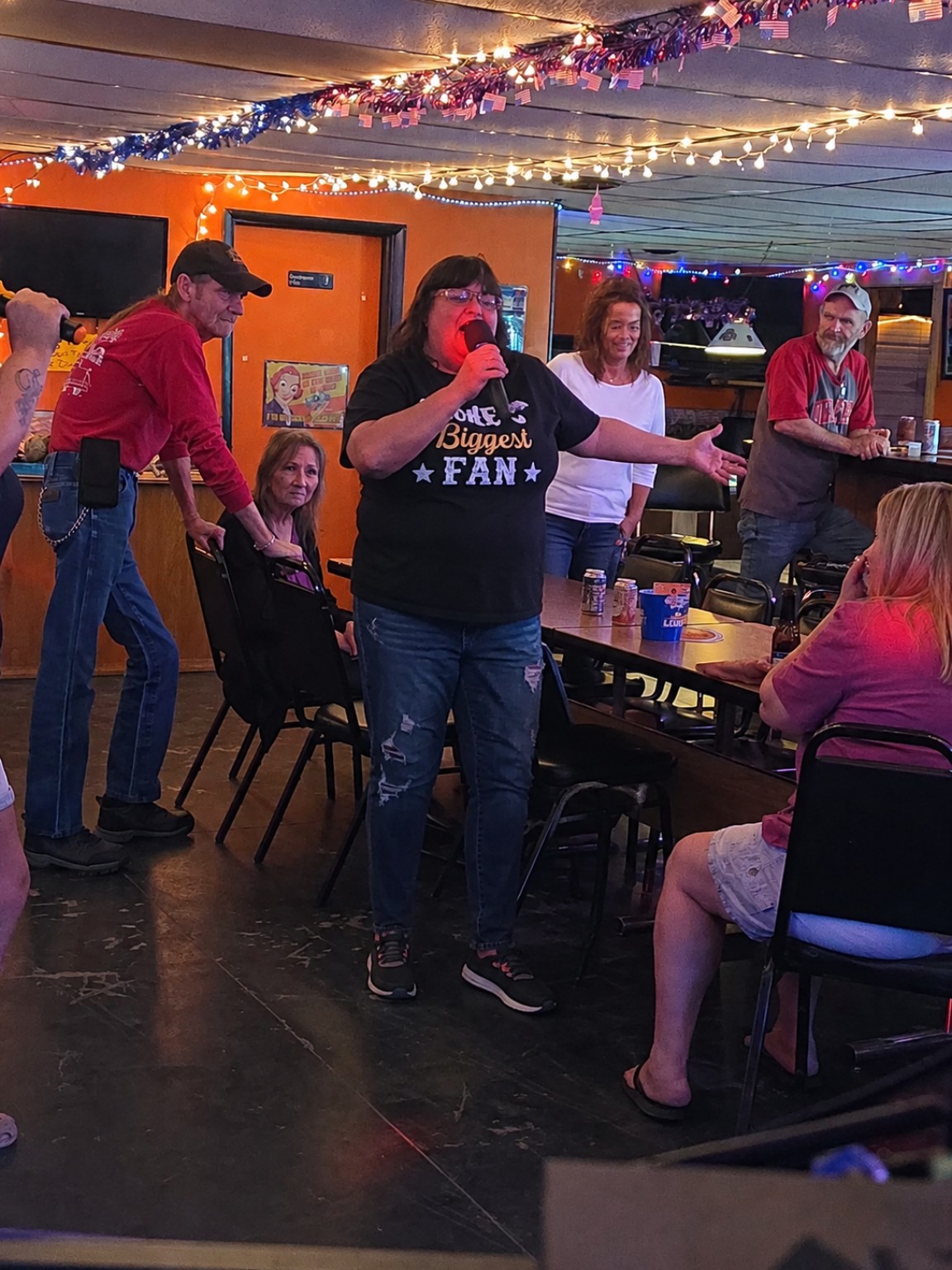 Woman singing karaoke for friends