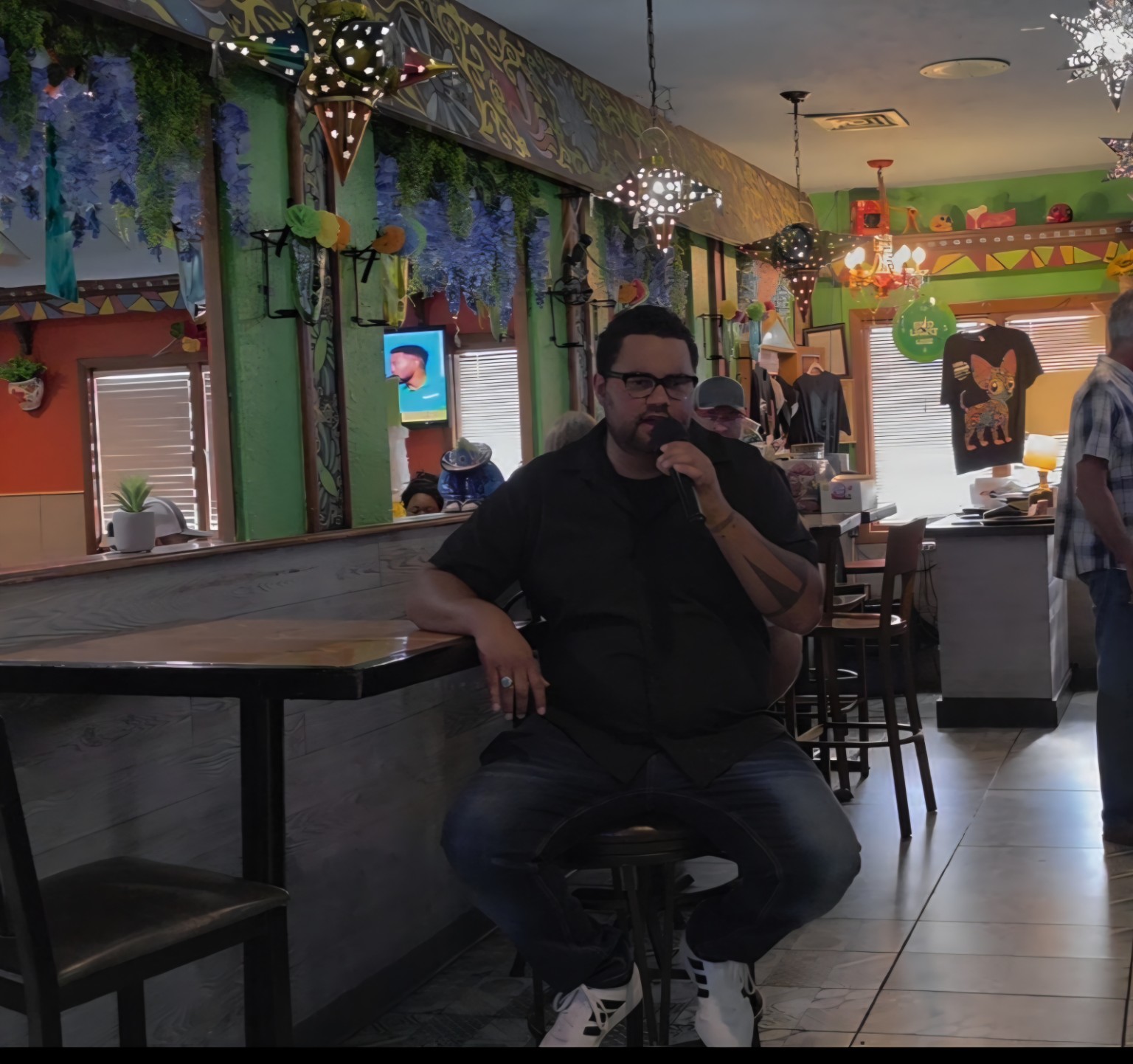 Man singing karaoke while seated at Los Cabos